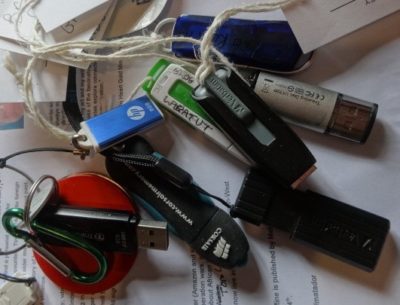 A jumble of USB sticks for storing work lie on a scrap of paper