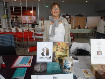 Ruth stands behind a display of her published books with her new novel and imprint on display