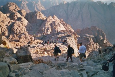A group of pilgrims make their way down a steep rocky path into a gorge from the summit of Mount Sinai