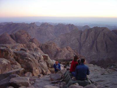 A group of pilgrims stare out over the montains of the Sinai desert