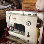 the photo shows a 1972 Bernina automatic sewing machine  next to a button box and a sewing table